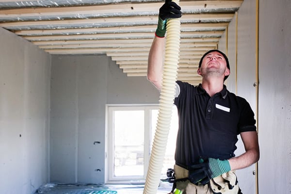 Construction Worker Insulating Wall with Fiberglass Batt